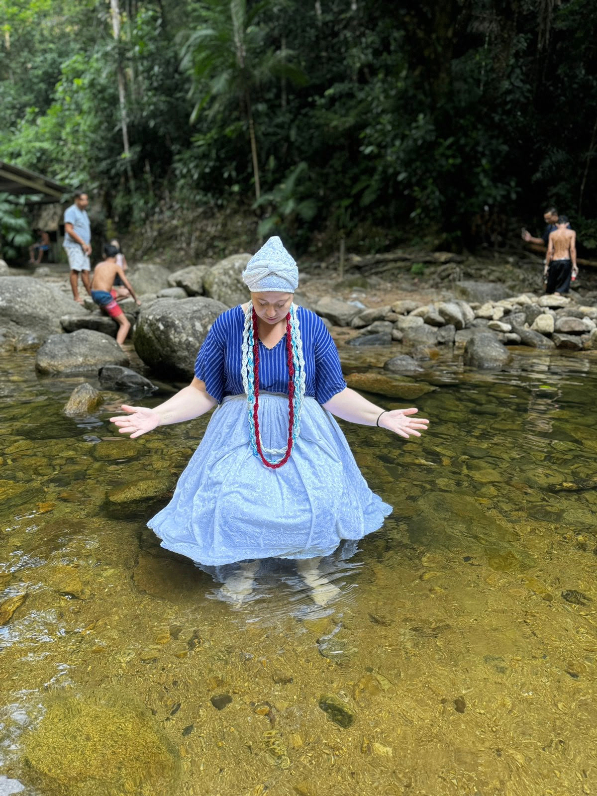 Mãe Lira em ritual espiritual nas águas da cachoeira